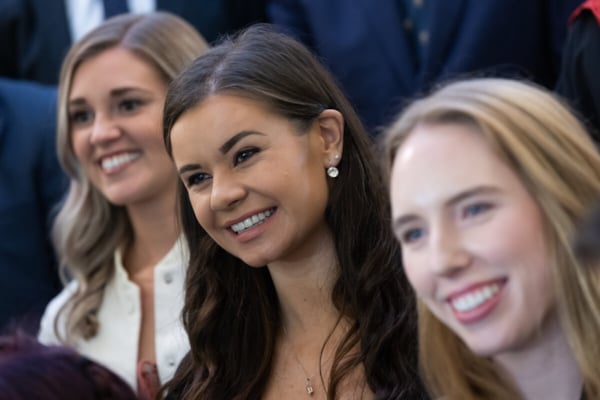 Woman smiling in audience at conferring ceremony